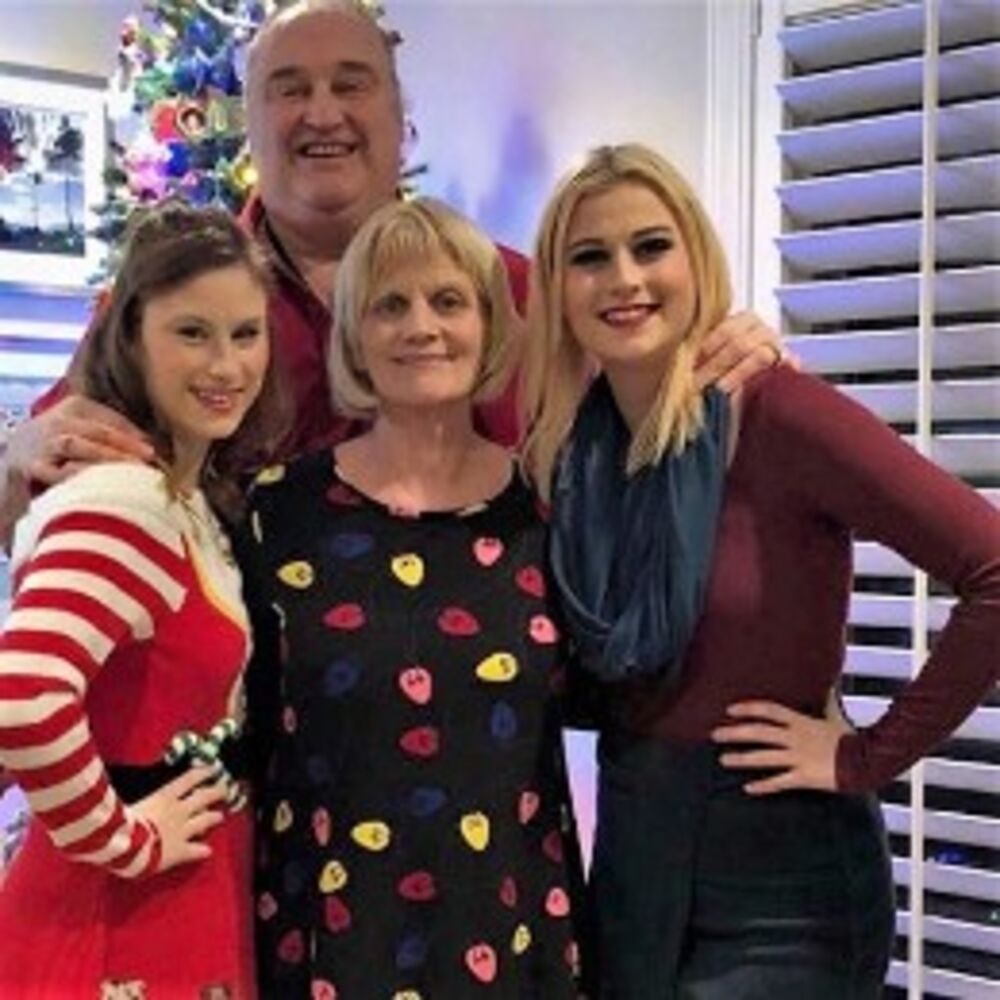 The owner and her three daughters smiling