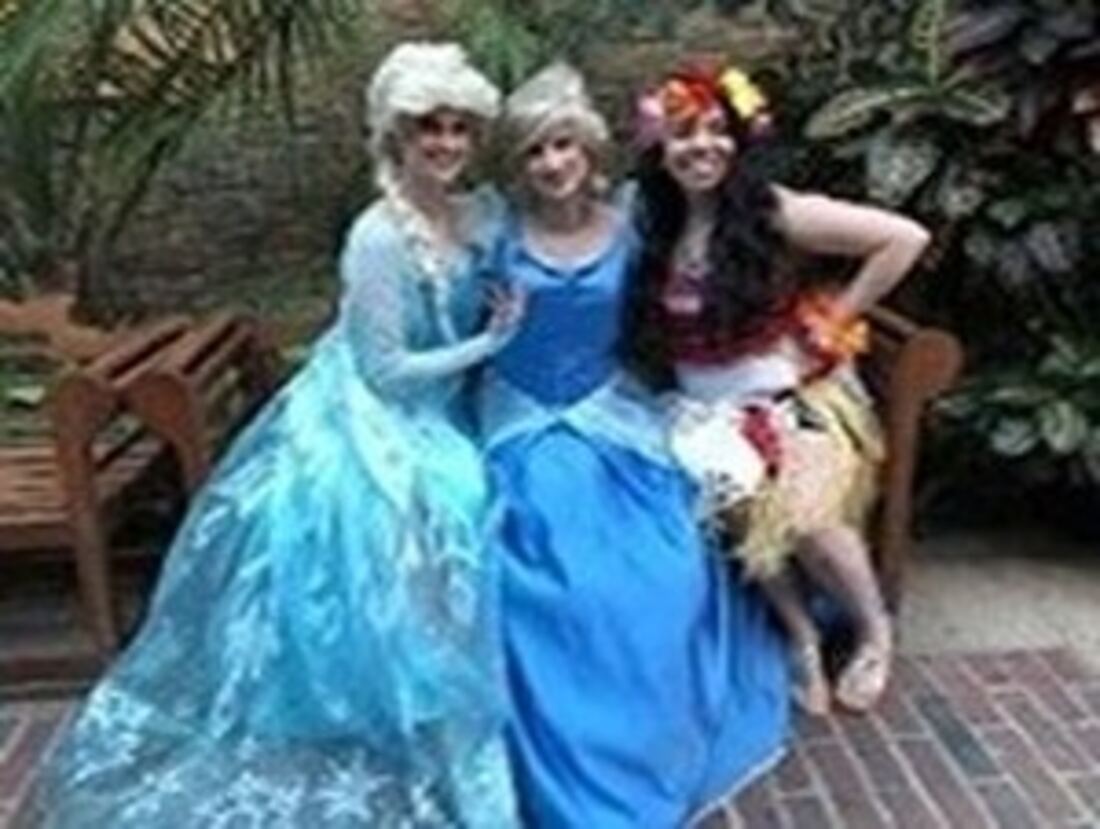 Three princess character actors smiling at a party
